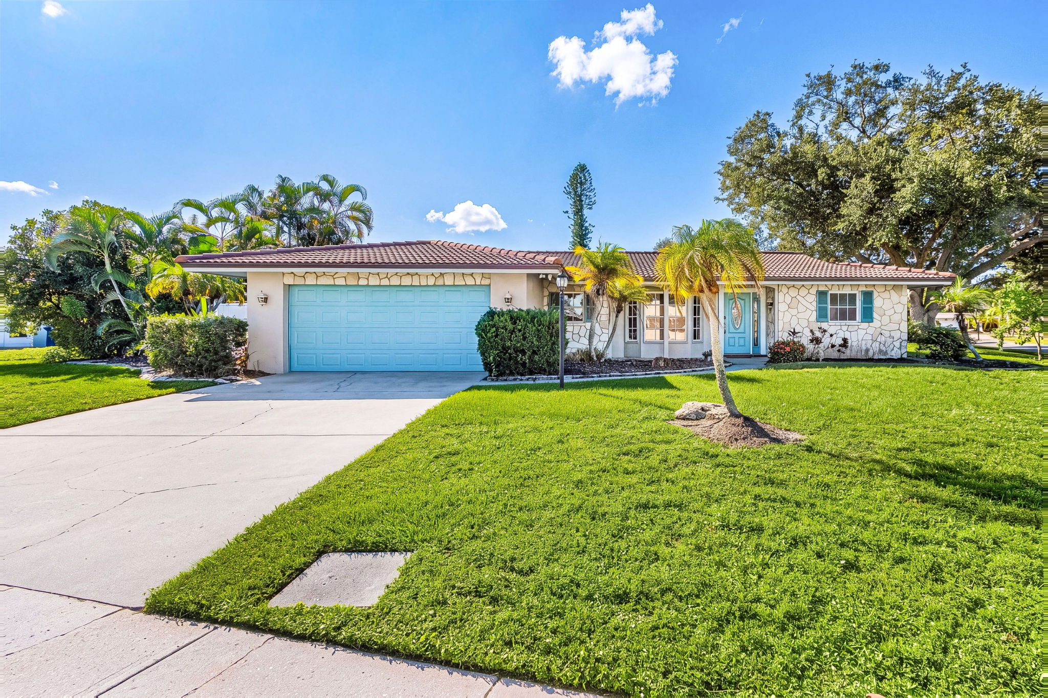 Front exterior with lawn and tropical landscaping
